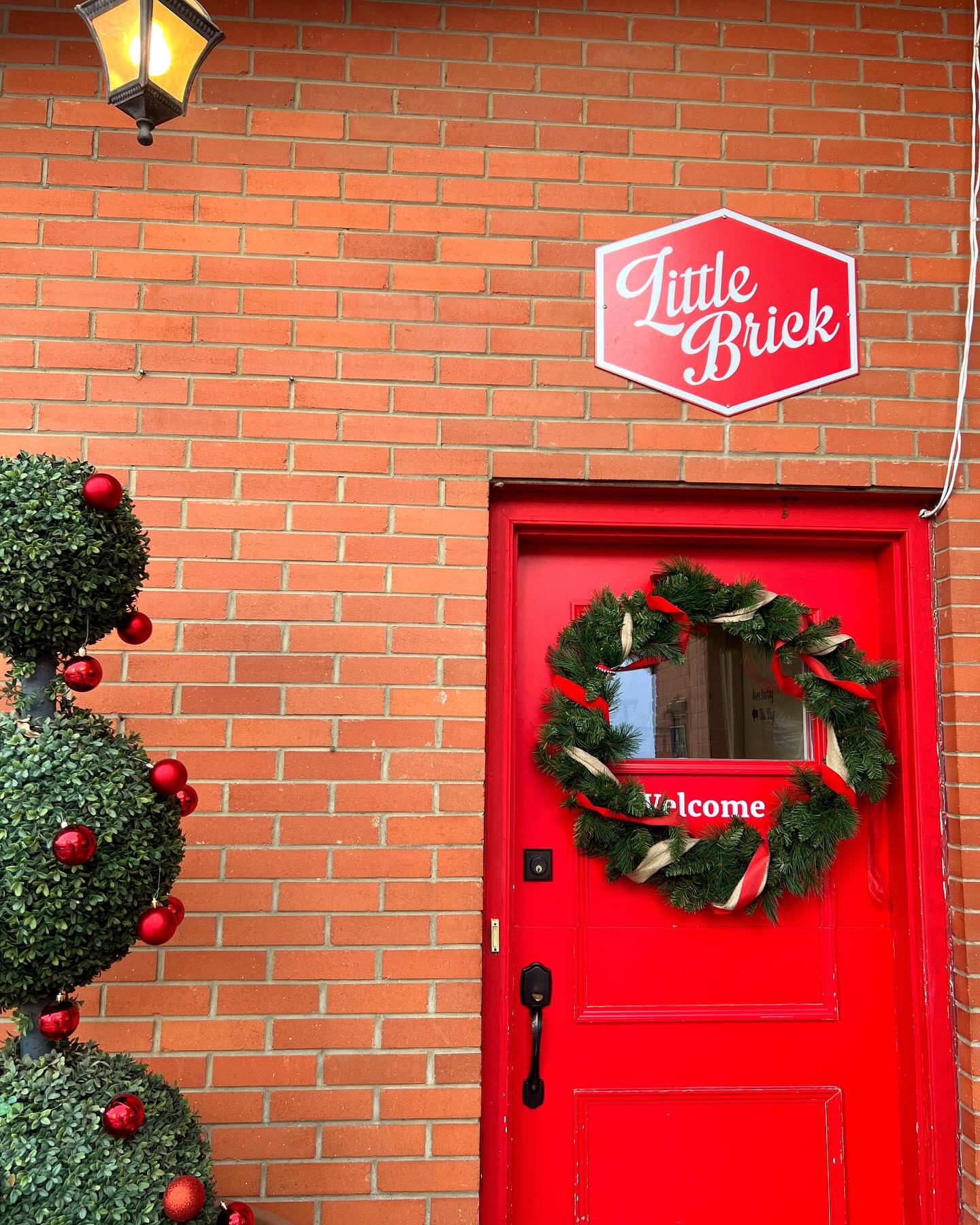 The red front door at Little Brick with a wreath